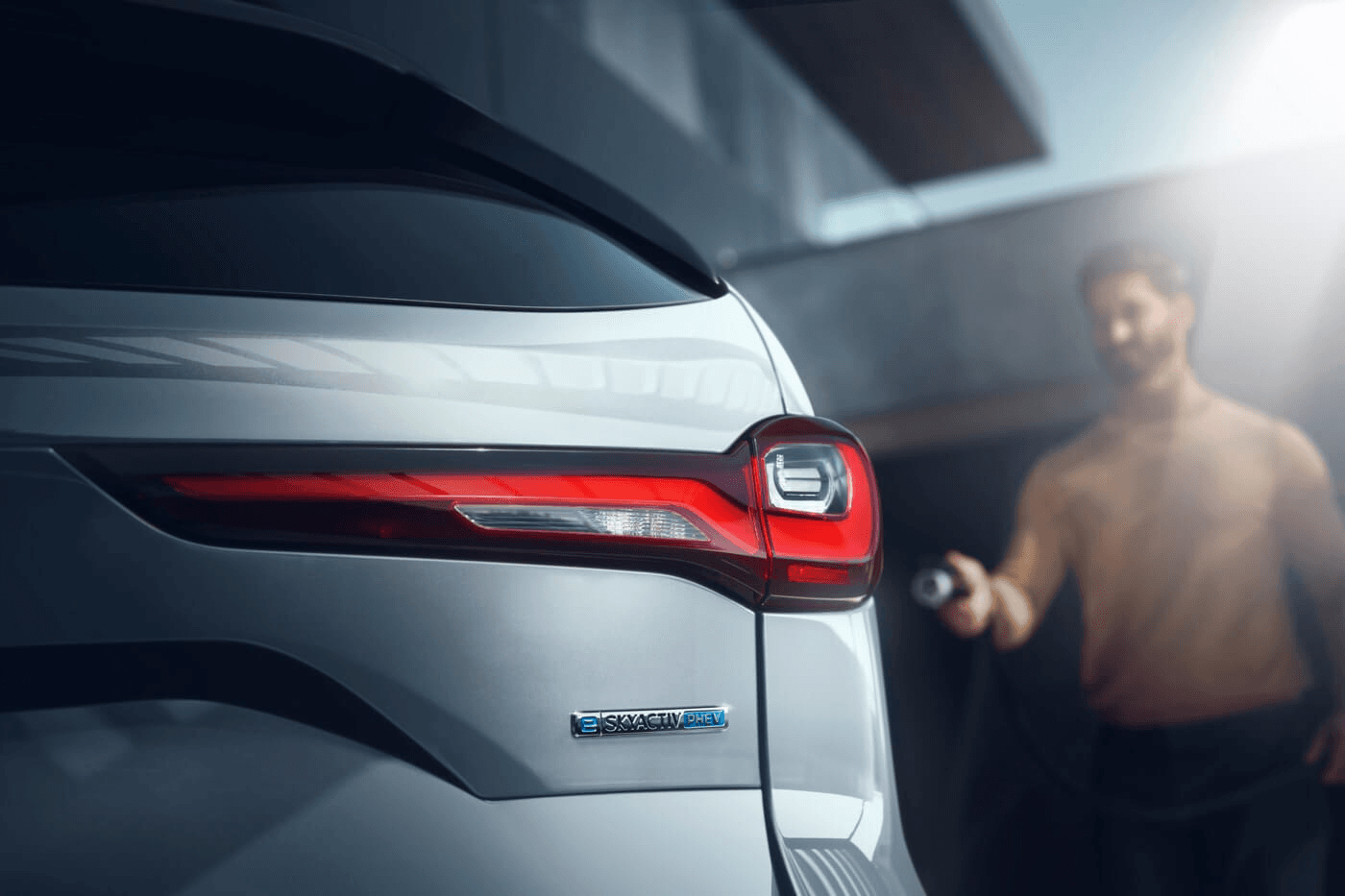 Personne s'apprêtant à charger le Mazda CX-90 PHEV 2025.