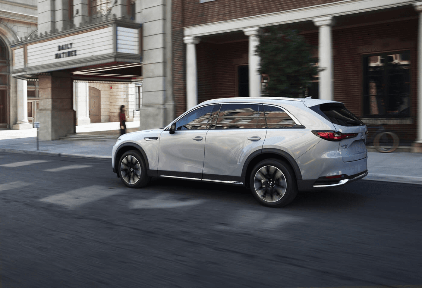 Vue latérale du Mazda CX-90 PHEV 2025 roulant en ville.